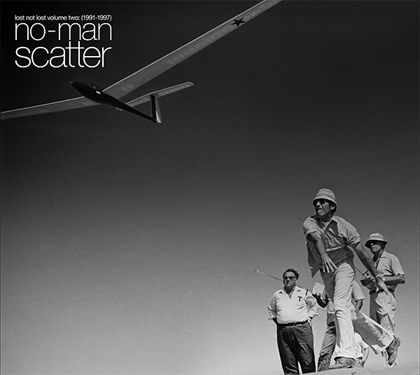 no-man Scatter. Four men outside, throwing a glider toy.